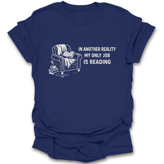 Navy blue t-shirt with a graphic of a couch, books, and a cup, and text 'In another reality my only job is reading' on a white background. funny book reading literary t shirt