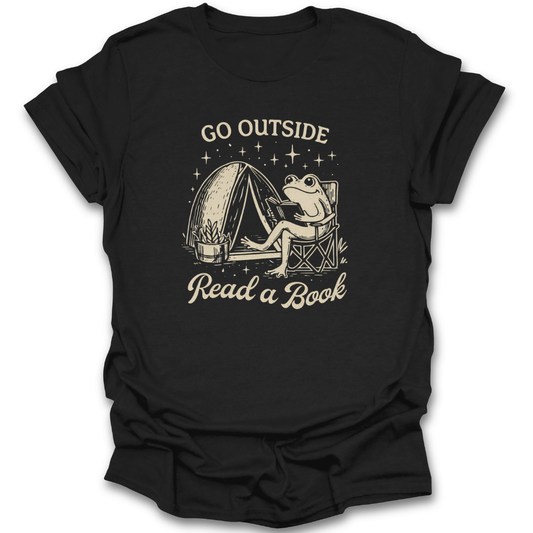 Black t-shirt with a graphic of a frog reading a book next to a tent and text 'Go Outside Read a Book' on a white background. funny book reading literary t shirt