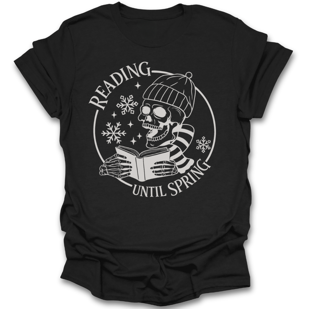 Black t-shirt with a skull wearing a beanie and reading a book graphic and 'Reading Until Spring' text. funny book reading literary t shirt
