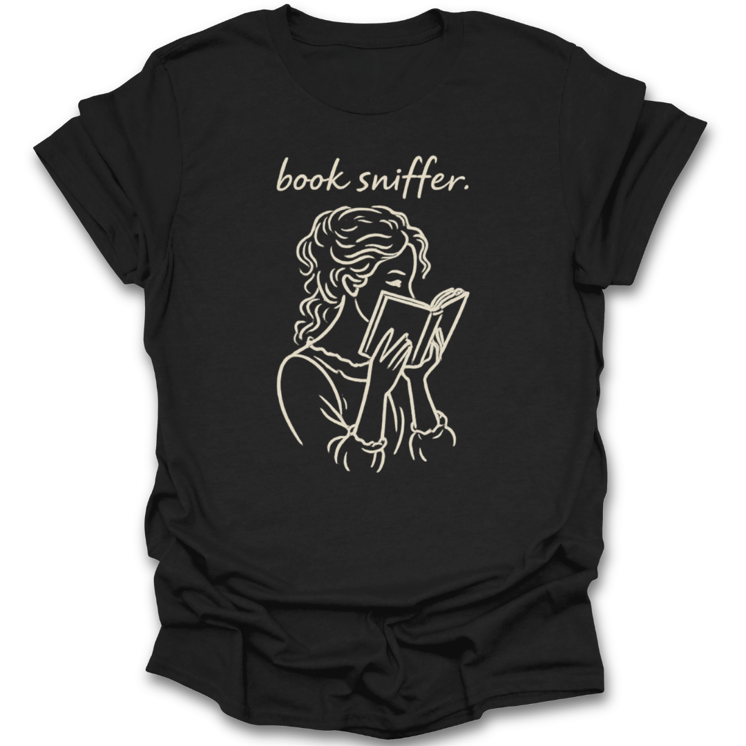 Black t-shirt with a graphic of a person reading a book and the text 'book sniffer' on a white background. funny book reading literary t shirt