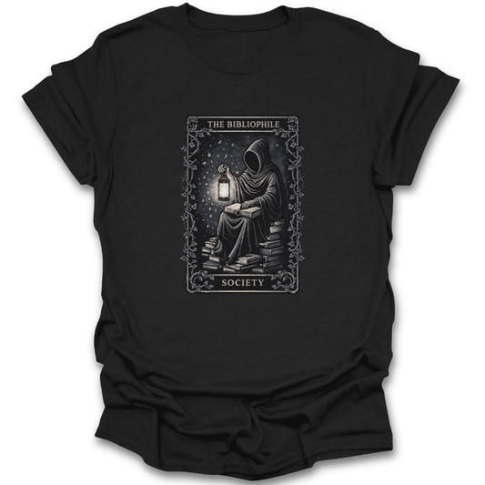 Black t-shirt with a graphic design of a person reading a book by a lantern, labeled 'The Bibliophile Society'.  book reading literary t shirt