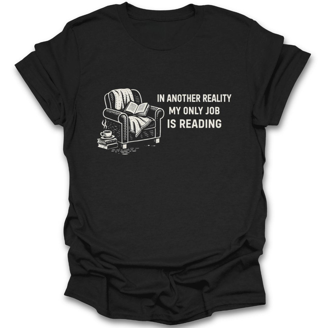 Black t-shirt with a graphic of a couch, books, and a cup, and text 'In another reality my only job is reading' on a white background. funny book reading literary t shirt