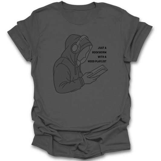 Gray t-shirt with a graphic of a person wearing headphones and holding a book, with text 'Just a bookworm with a hood playlist'. funny book reading literary t shirt