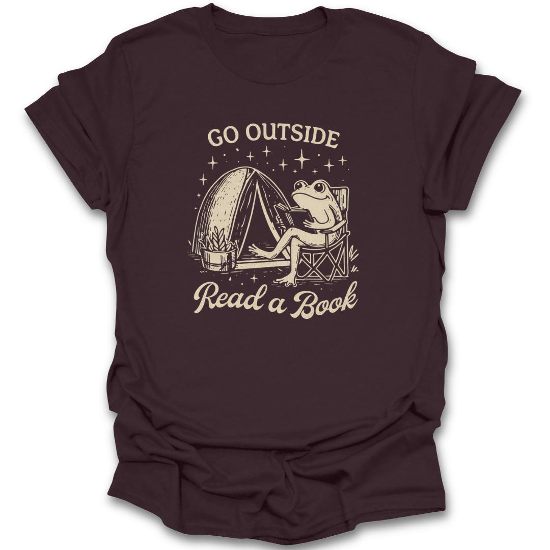 Brown t-shirt with a graphic of a frog reading a book next to a tent and text 'Go Outside Read a Book' on a white background. funny book reading literary t shirt
