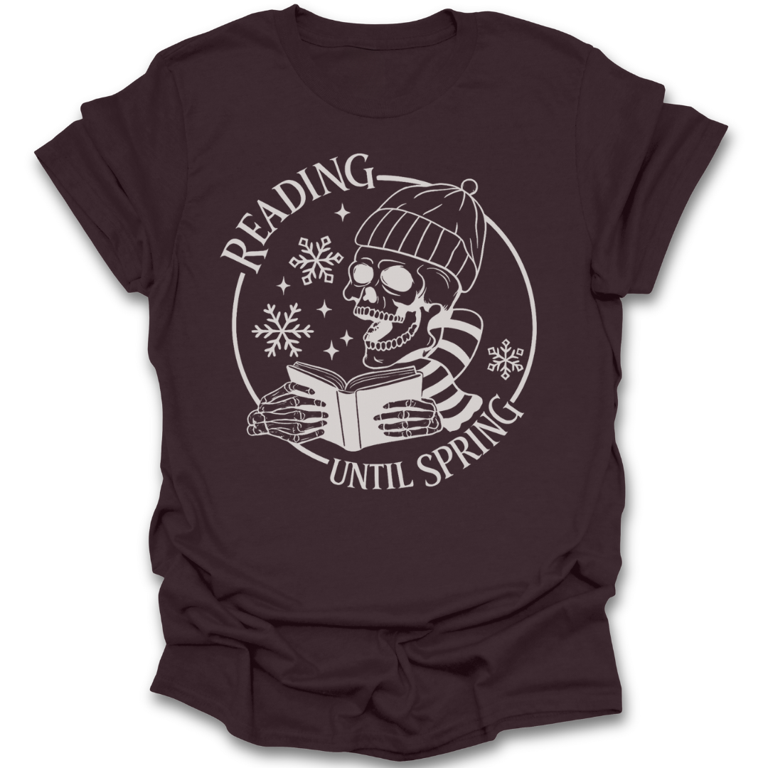 Brown t-shirt with a skull reading a book graphic and text 'Reading Until Spring' on a white background book t shirt