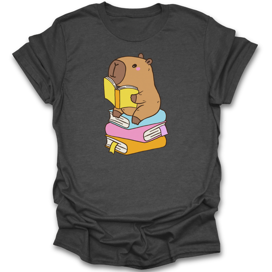 Dark gray t-shirt with a cartoon capybara reading a book design on a white background