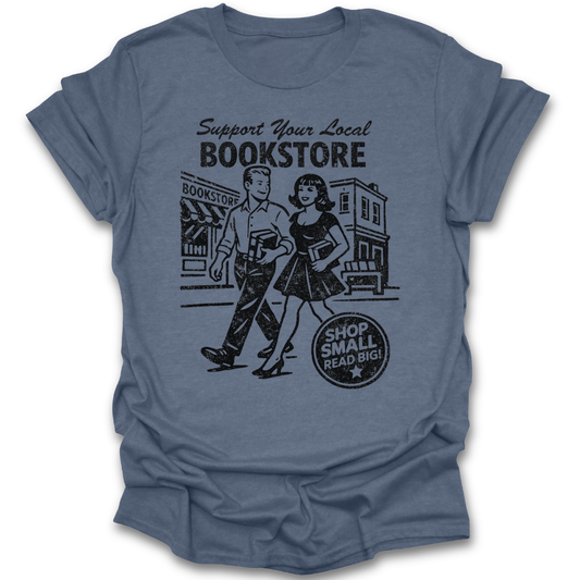 Blue t-shirt with a graphic of a man and woman holding books and text 'Support Your Local Bookstore' on a white background. funny book reading literary t shirt