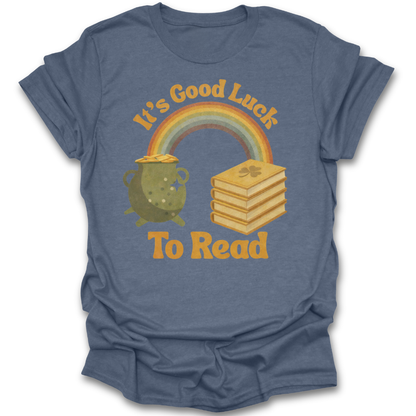 Blue t-shirt with a graphic of a rainbow, pot of gold, and books with text 'It's Good Luck To Read' on a white background. st patricks day funny book reading literary t shirt