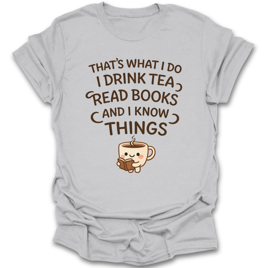 Gray t-shirt with a graphic of a teacup reading a book and text 'That's what I do, I drink tea, read books, and I know things' on a white background. funny book reading literary t shirt