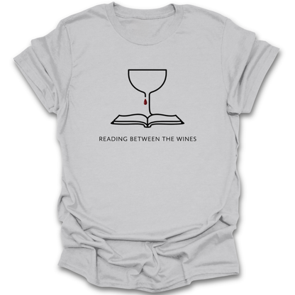 Gray t-shirt with a graphic design and text 'Reading Between The Wines' on a white background book lover shirt, reading shirt, wine lover shirt, funny book shirt, book club shirt, bibliophile gift, reader gift, bookworm shirt, literary shirt, wine and books shirt, funny reader tee, bookish apparel, bookstore shirt, librarian gift