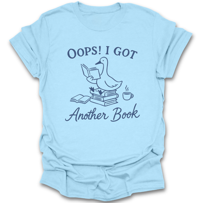Light blue t-shirt with a graphic and text 'Oops! I got another book' on a white background. oops i got another book shirt, funny book lover shirt, bookish t-shirt, reader gift, bookworm apparel, bookstore shirt, bibliophile tee, reading humor shirt, book club gift, coffee and books shirt
