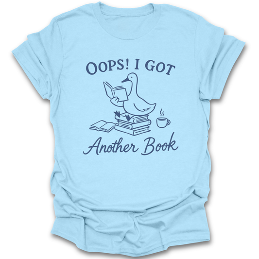 Light blue t-shirt with a graphic and text 'Oops! I got another book' on a white background. oops i got another book shirt, funny book lover shirt, bookish t-shirt, reader gift, bookworm apparel, bookstore shirt, bibliophile tee, reading humor shirt, book club gift, coffee and books shirt