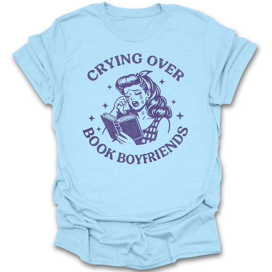 Light blue t-shirt with purple graphic and text 'Crying over book boyfriends' on a white background romance reading t shirt