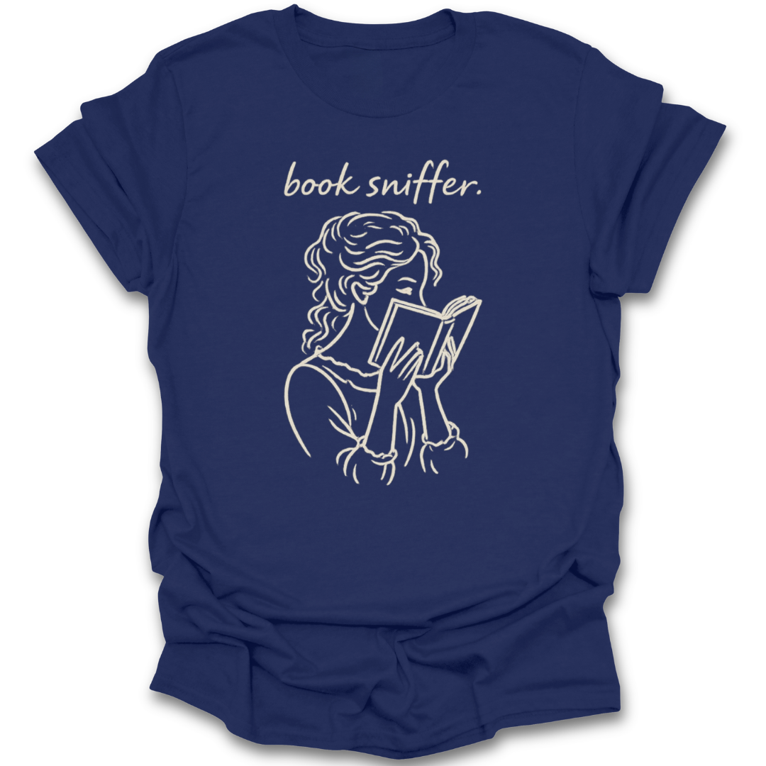 Navy blue t-shirt with a graphic of a person reading a book and the text 'book sniffer' on a white background. funny book reading literary t shirt