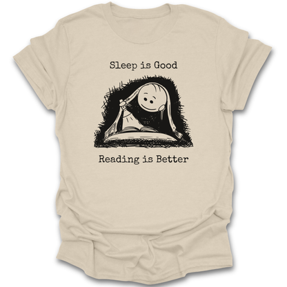 Beige t-shirt with a graphic of a book and sleeping face, text 'Sleep is Good Reading is Better' on a white background. cute  funny book reading literary t shirt