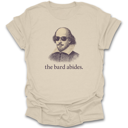 Beige t-shirt with a graphic of Shakespeare wearing sunglasses and the text 'the bard abides' on a white background. funny book reading literary t shirt