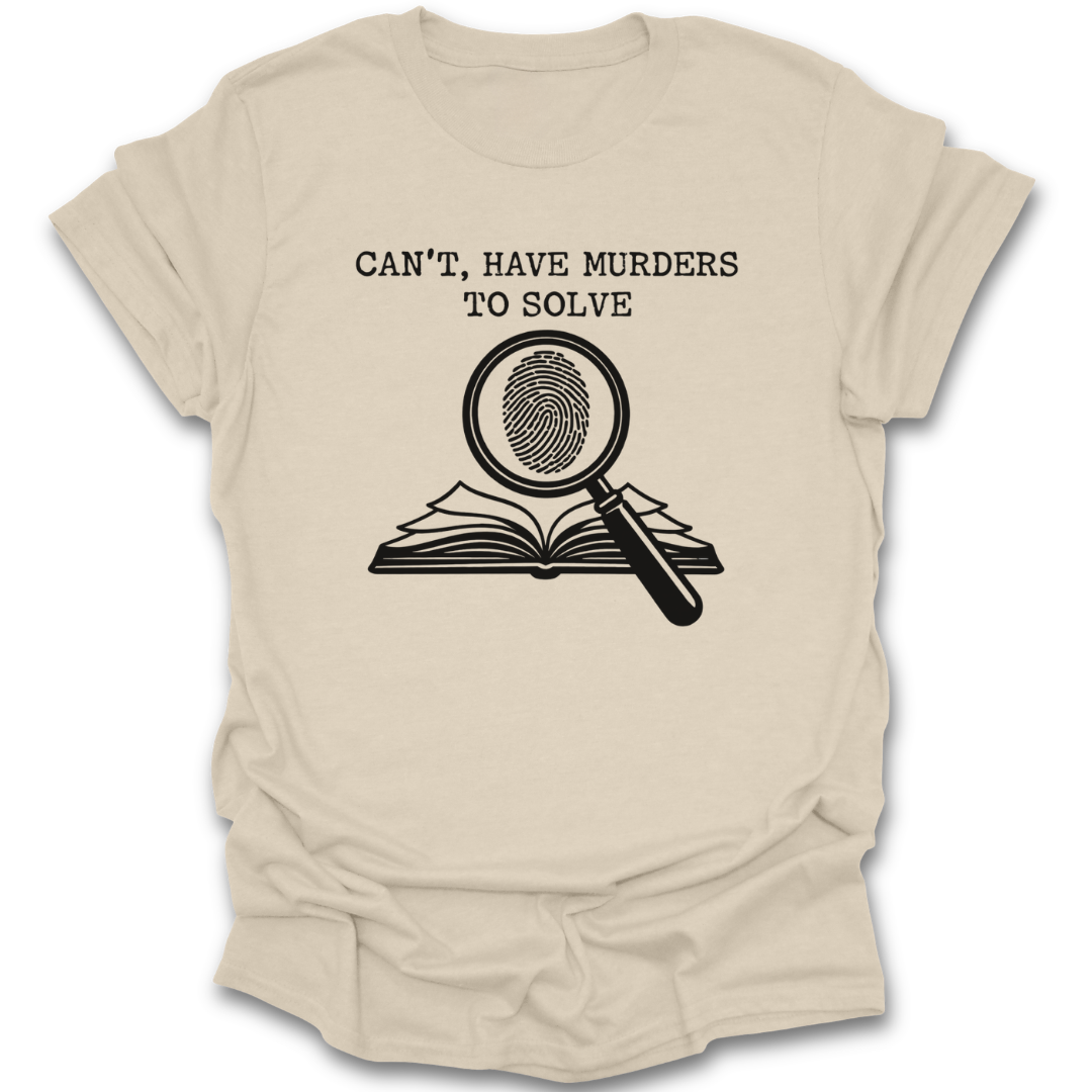 Beige t-shirt with graphic design and text 'Can't, have murders to solve' on a white background true crime murder mystery funny book reading literary t shirt