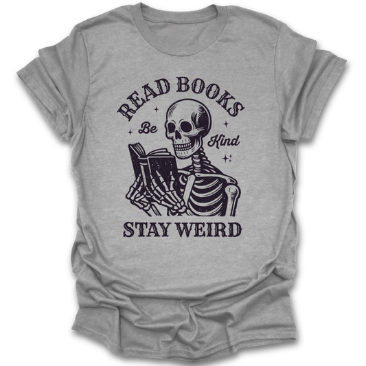 Gray t-shirt with skeleton reading a book graphic and text 'Read Books, Be Kind, Stay Weird' on a white background. funny book reading literary t shirt