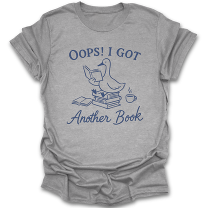 Gray t-shirt with blue graphic and text 'Oops! I got another book' on a white background. oops i got another book shirt, funny book lover shirt, bookish t-shirt, reader gift, bookworm apparel, bookstore shirt, bibliophile tee, reading humor shirt, book club gift, coffee and books shirt