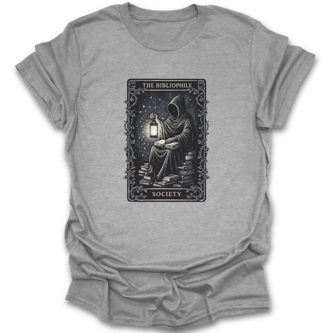 Gray t-shirt with a graphic design of a person reading a book by a lantern, labeled 'The Bibliophile Society'.  book reading literary t shirt