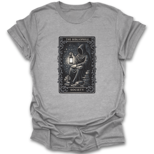 Gray t-shirt with a graphic design of a person reading a book by a lantern, labeled 'The Bibliophile Society'.  book reading literary t shirt