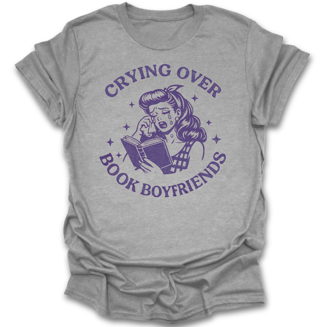 Gray t-shirt with purple graphic and text 'Crying over book boyfriends' on a white background romance funny book reading literary t shirt