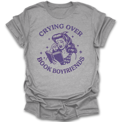 Gray t-shirt with purple graphic and text 'Crying over book boyfriends' on a white background romance funny book reading literary t shirt